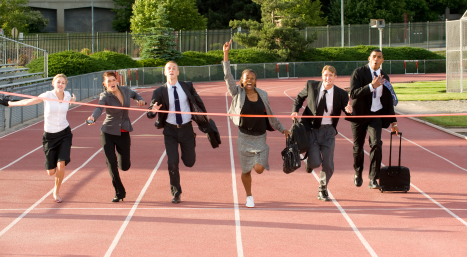 Business people are running on a track toward a finish line