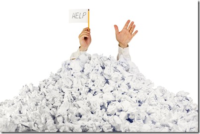 Person under crumpled pile of papers with hand holding a help sign / isolated on white