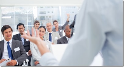 Woman gesturing with her hand while a business team is watching her