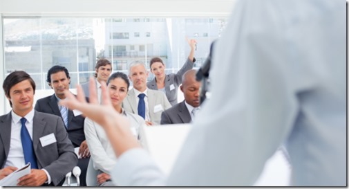 Woman gesturing with her hand while a business team is watching her