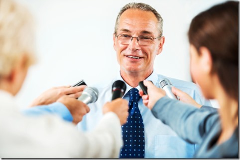 Mature man executive being questioned by journalists. 