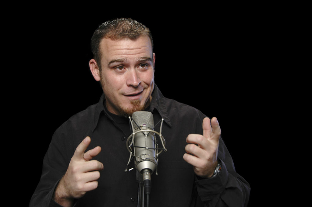 Comedian performing on a black background