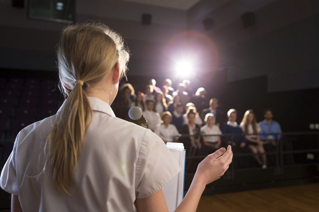 Woman reading a speech in a dark room