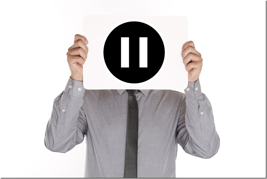 Man holding pause button sign in front of his face