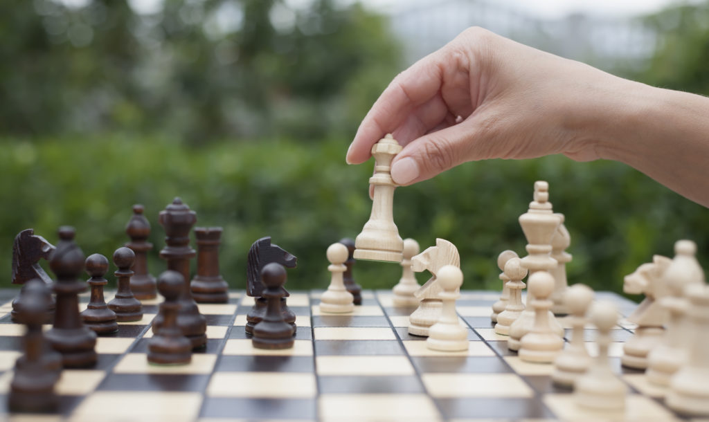 Woman's hand moving chess pieces