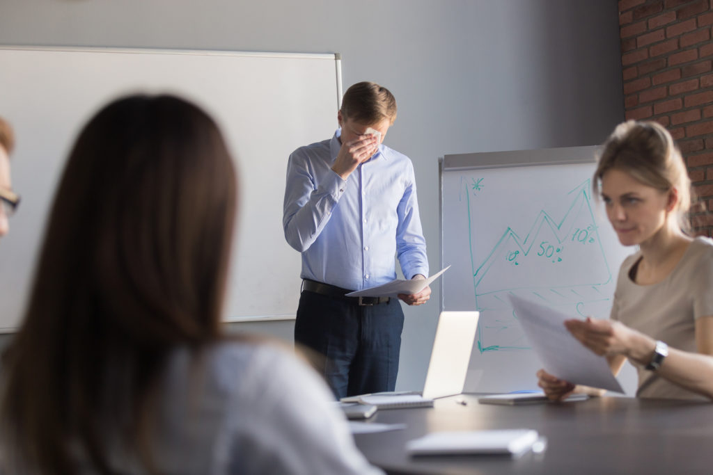 Stressed male speaker or presenter worried before making presentation for colleagues in meeting room