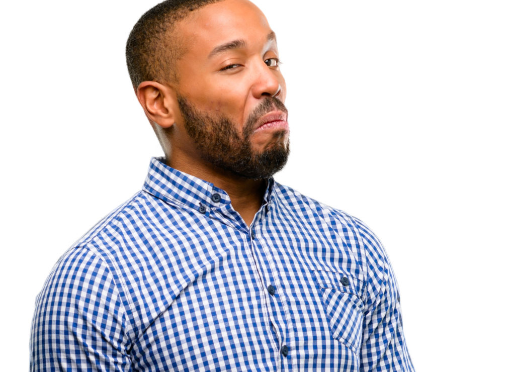 Man with beard in front of a white background appears to be skeptical