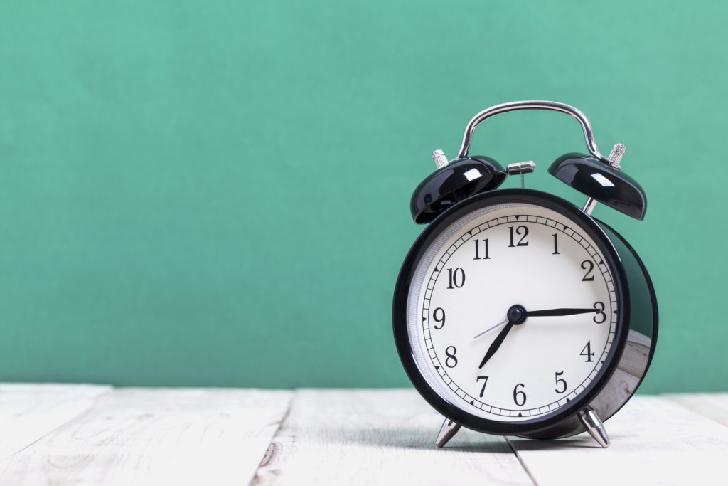 Black Retro alarm clock on wooden board