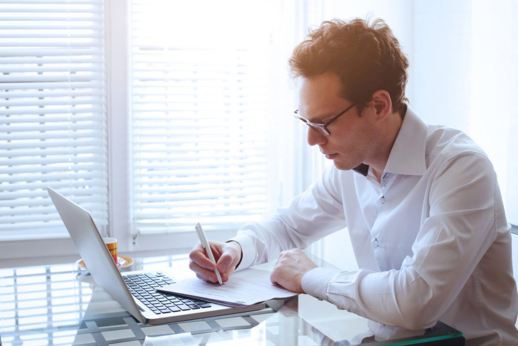 Business man signing documents at desk