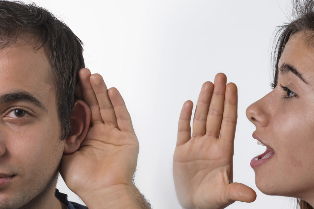 Woman whispering in man's ear