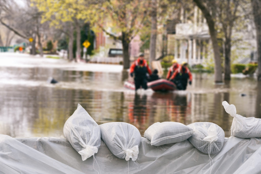 Flood Protection Sandbags with flooded homes in the background