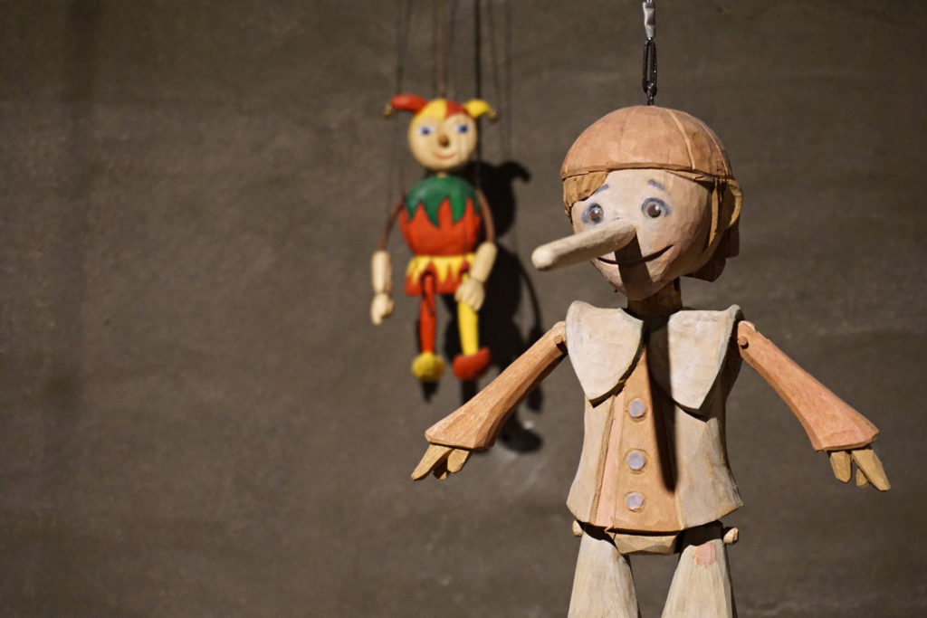 A wooden marionette hanging on a wall.