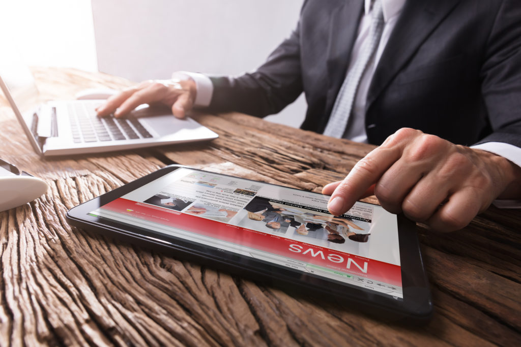 Businessman Reading News On Digital Tablet