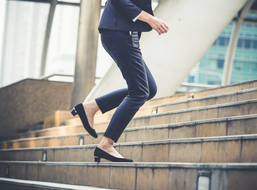 Close up legs of businesswoman running up stairs