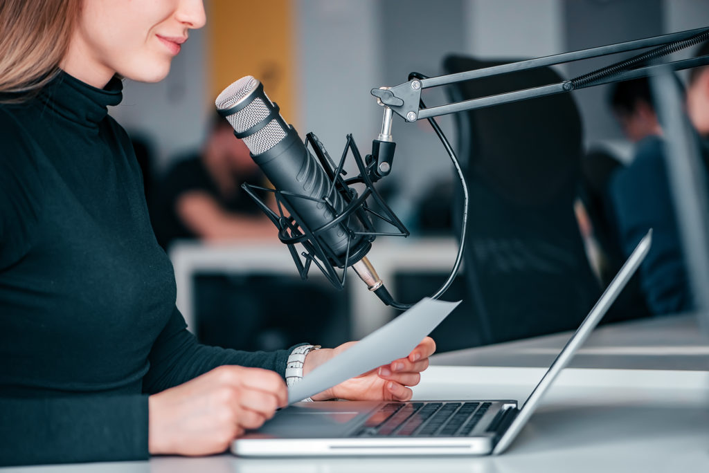 A woman talkng ino a mic during a podcast