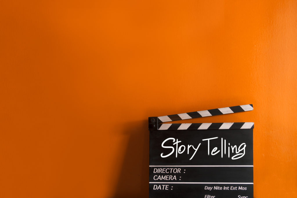 A storytelling director's sign on an orange background