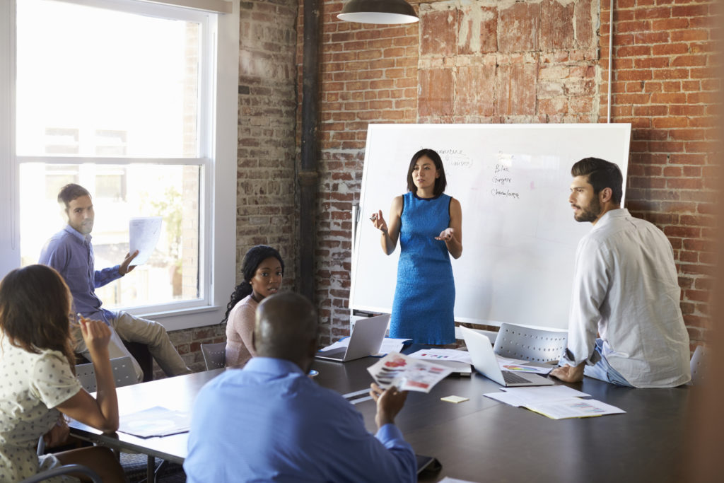 Businesswoman At Whiteboard In Brainstorming Meeting