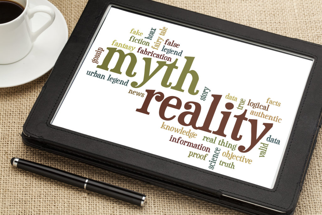 A tablet with "myth," "reality," and other words in a word cloud