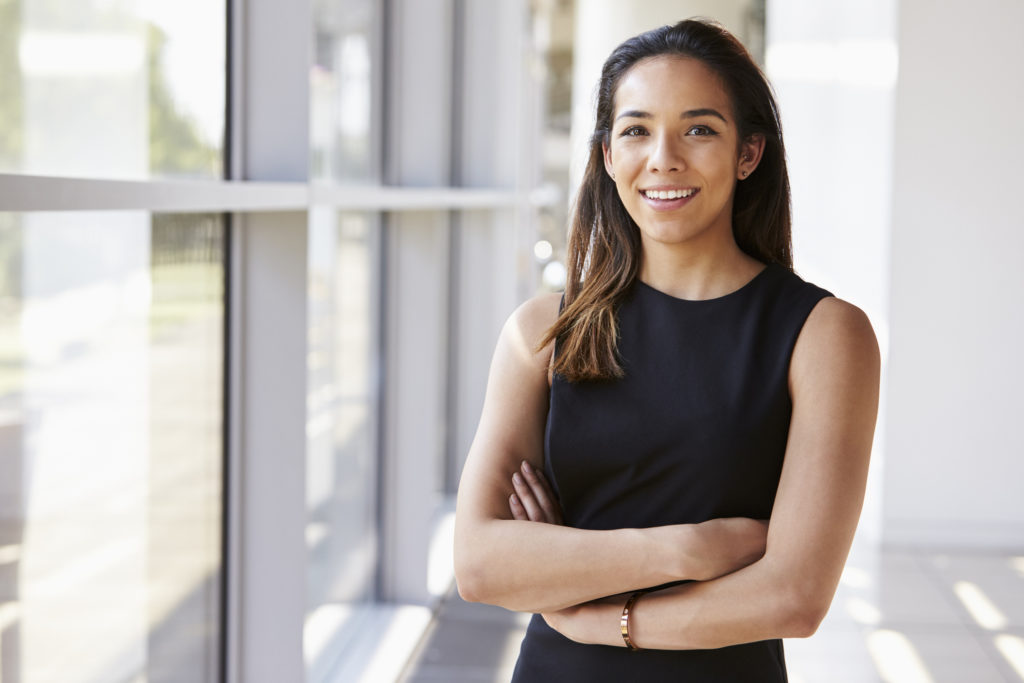 Portrait of young woman looking to camera with arms crossed