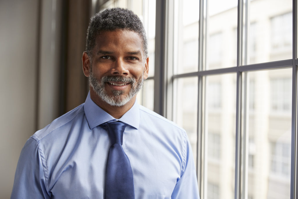 Middle aged black businessman smiling to camera