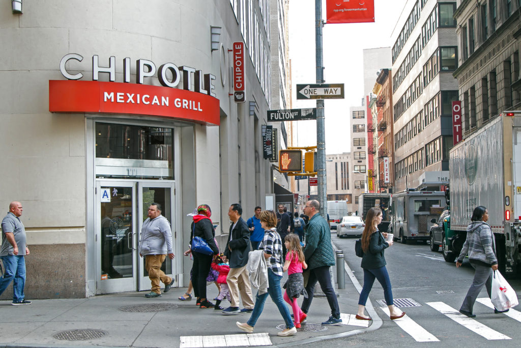 People walking outside a Chipotle restaurant in New York City