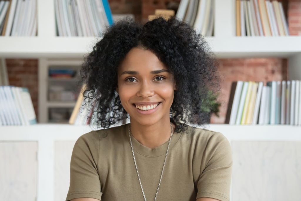 Smiling young african american woman looking at camera webcam