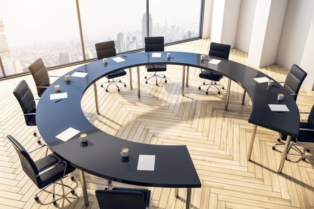 Horseshoe shape table and chairs in conference room