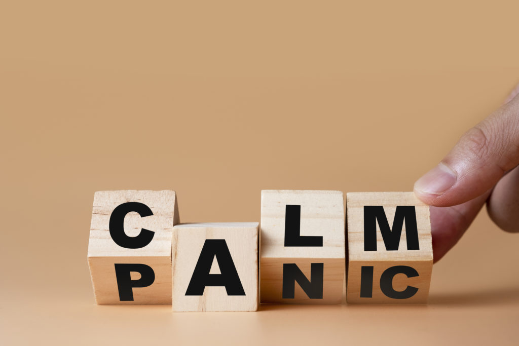 Hand flipping wooden cubes for change wording" Panic " to " Calm". Mindset is important for human development.