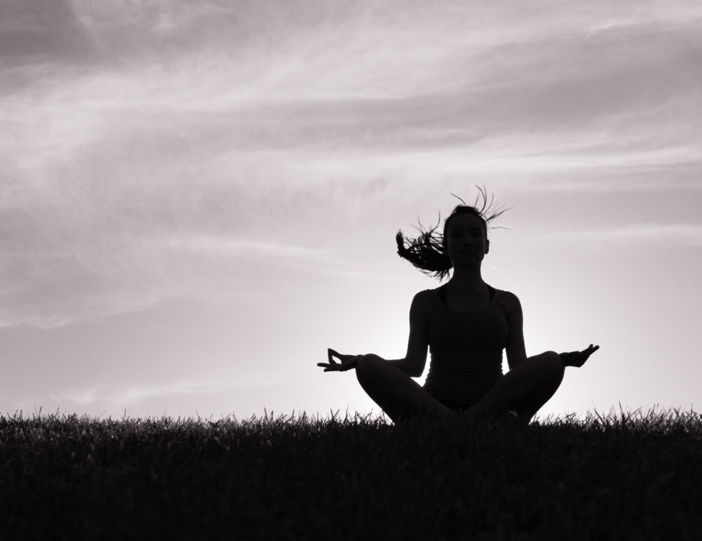 A black and white image of a woman meditating